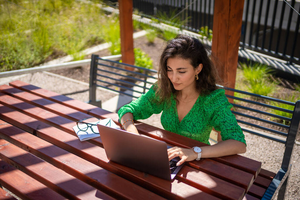 Blanke vrouw werkt met laptop computer buiten kantoor. Hoge kwaliteit foto - Foto, afbeelding