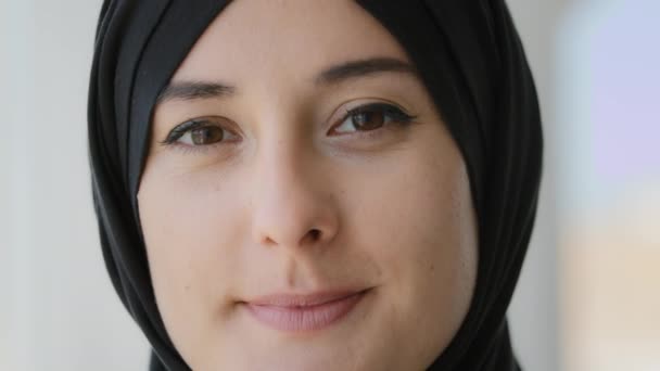 Privacy e segreti. Ritratto estremo da vicino Musulmana araba donna islamica in hijab nero mettere il dito sulle labbra mostrando shh gesto silenzio silenzio gesto vieta di parlare informazioni segretezza sorridente - Filmati, video