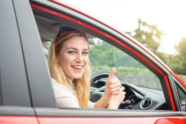 Beautiful blonde driving a car on the road. - 写真・画像