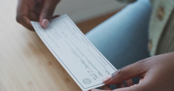 A business woman is preparing to write a check. Salary concept. Payment by check,African American woman handing over a check to another woman. - Materiał filmowy, wideo