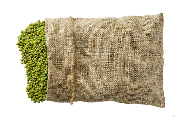 raw green mung beans in sack bag top view.Sack with mung beans flat lay . dry green mung beans in burlap bag and heap of mung beans. - Foto, afbeelding