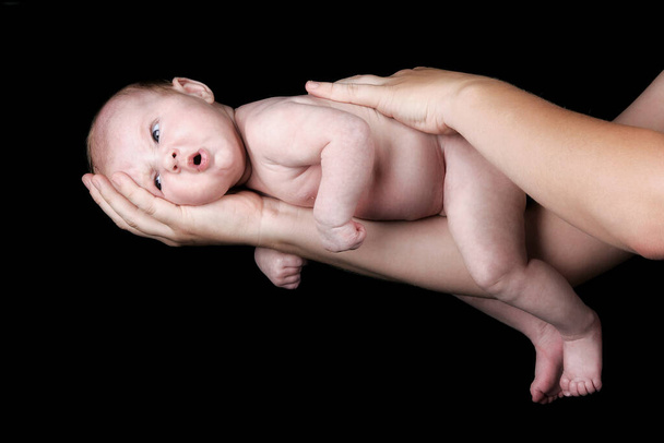 infant on the arm of his mother - 写真・画像
