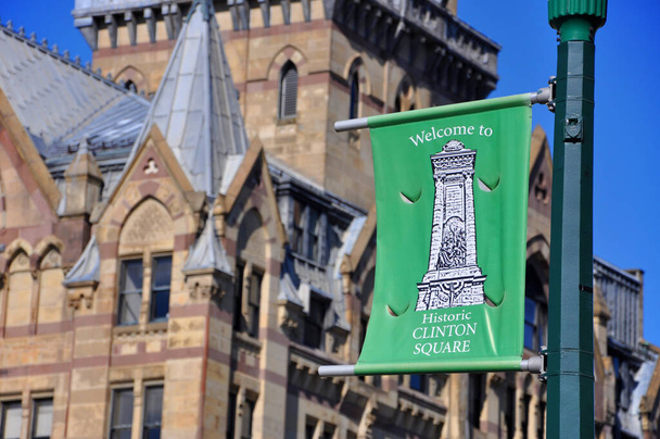 Welcome to Historic Clinton Square flag in front of Syracuse Savings Bank Building at Clinton Square in downtown Syracuse, New York State NY, USA.  - Photo, image