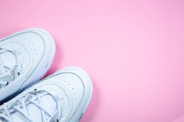 Modern sneakers on the pink background. White leather trainers on big sole with spikes. Close up. - Photo, Image
