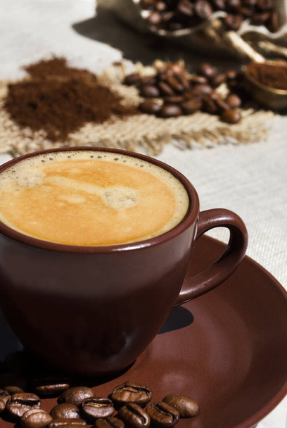Kubek kawy na tle ziaren kawy na stole. Jestem Java. Arabica jest najczęstszym rodzajem kawy. - Zdjęcie, obraz