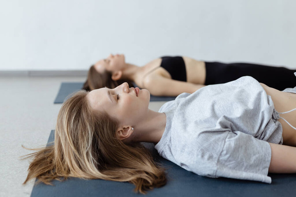 Fitness group doing practicing in a yoga class. Shavasana or corps pose, yoga practice.  - Foto, afbeelding