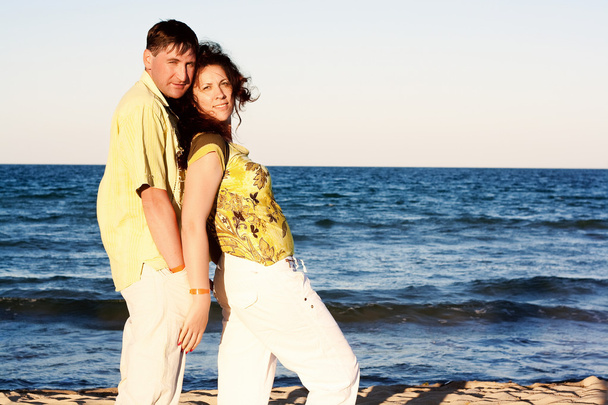 ビーチでロマンチックな抱擁で男と女のカップル - 写真・画像