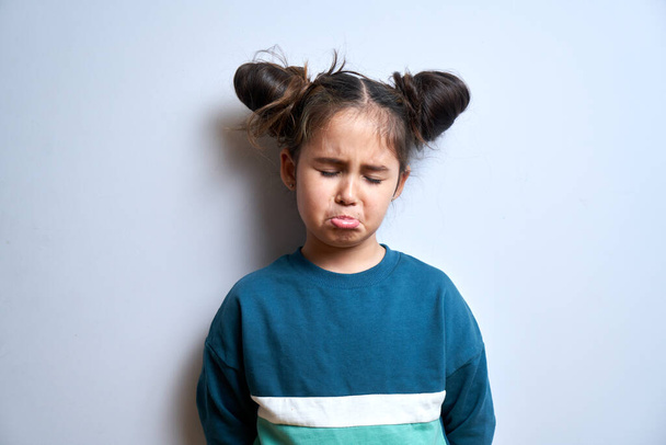Portrait of upset brunette little girl with sad face crying isolated on white background - Photo, Image