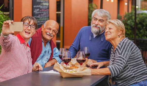 Elderly people take a selfie at the table - Mature couple have fun at the restaurant - Senior concept - Zdjęcie, obraz