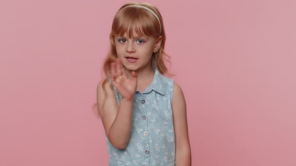 Shh be quiet please. Preteen child girl kid presses index finger to lips makes silence hush gesture sign do not tells gossip secret. Little toddler children isolated alone on studio pink background - 映像、動画