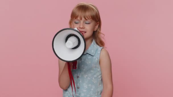 Preteen child girl kid talking with megaphone, proclaiming news, loudly announcing advertisement warning using loudspeaker to shout speech. Little toddler children isolated on studio pink background - Footage, Video