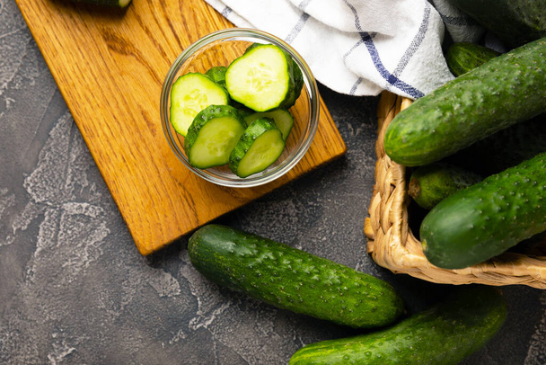 Fresh organic cucumbers against black marble background.Cucumber slices. Salad ingredient. Fresh vegetables. Vegan food. Healthy food. Fresh organic vegetables. - Zdjęcie, obraz