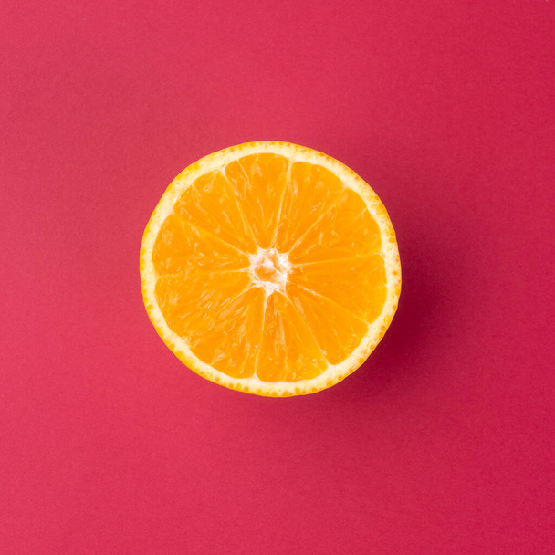 Orange half isolated over red textured background. - Foto, Imagen