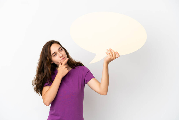 Young caucasian woman isolated on white background holding an empty speech bubble and thinking - Foto, Bild