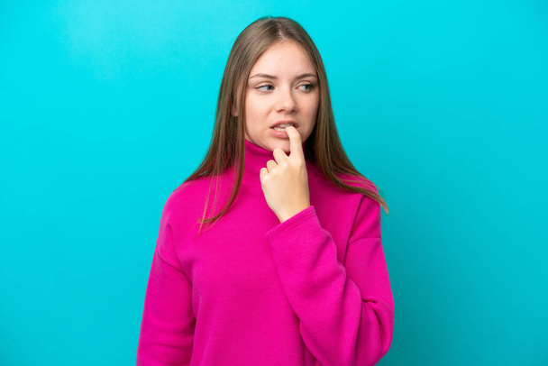 Young Lithuanian woman isolated on blue background nervous and scared - Foto, afbeelding