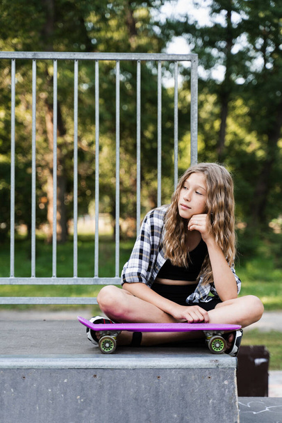 Ενεργό παιδί με penny board κάθεται σε skate sport ράμπα. Ακραίος τρόπος ζωής. Δημιουργική διαφήμιση για αθλητικά παιδικά καταστήματα - Φωτογραφία, εικόνα