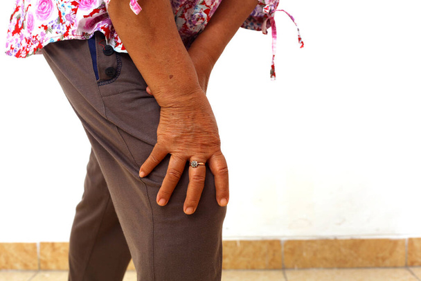 Donna anziana che tiene il ginocchio dolorante. Dolore alla gamba. Vecchiaia, concetto di problemi di salute. Isolato - Foto, immagini