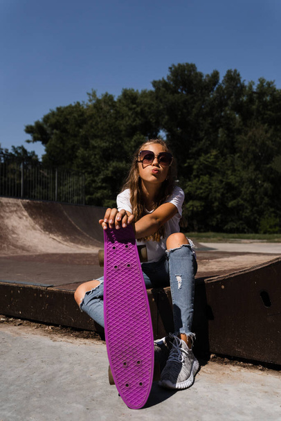 Active child with penny board sitting on skate sport ramp. Extreme sport lifestyle. Creative advertising for sports children store - Zdjęcie, obraz