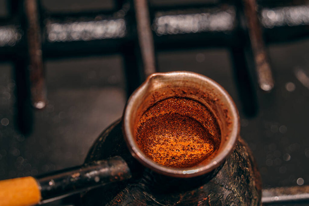 coffee is brewed in a copper cezve on a gas stove, coffee cream close-up, top view - Foto, Imagem