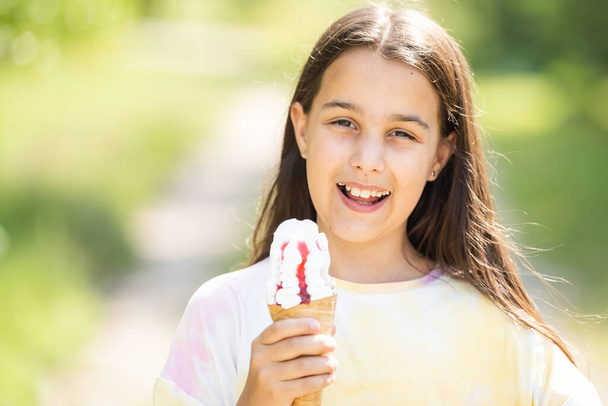 Aranyos lány eszik fagylaltot. - Fotó, kép