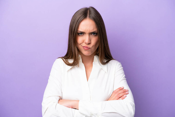 Молода біла жінка ізольована на фіолетовому фоні з нещасливим виразом
 - Фото, зображення