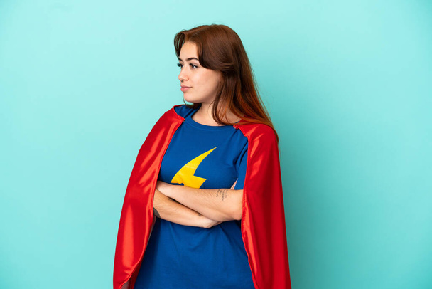 Young caucasian woman isolated on white background in superhero costume with arms crossed - Фото, зображення