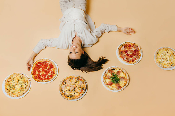 Фото в стиле поп-арта. Девушка с большим количеством пиццы на цветном фоне - Фото, изображение