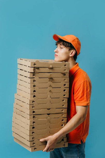 Pizza delivery concept. Pizza delivery man with lots of pizza boxes. Photo mockup. - Foto, Imagen