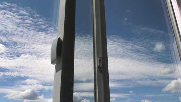 Guardando in alto e attraverso una finestra di vetro moderno fuori ad un bel cielo blu con le nuvole soffici, time lapse. - Filmati, video