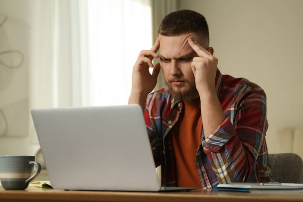 Online test. Man studying with laptop at home - Fotoğraf, Görsel