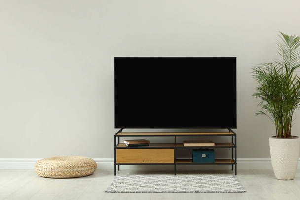 Stylish wide TV set on stand in room - Φωτογραφία, εικόνα