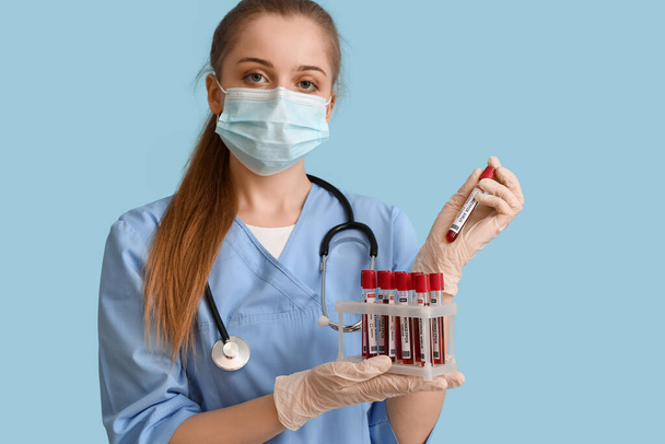 Doctor with samples of monkeypox virus on blue background - Фото, зображення