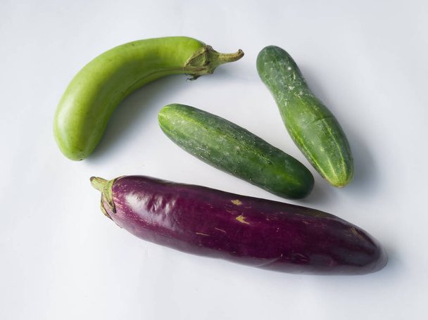 Raw vegetables consisting of purple green eggplant and cucumber - Zdjęcie, obraz
