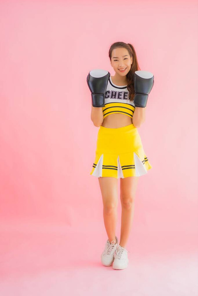 Portrait beautiful young asian woman cheerleader with boxing action on pink isolated background - Photo, Image
