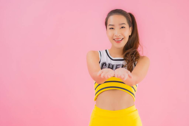Portrait beautiful young asian woman cheerleader on pink isolated background - Foto, Imagen