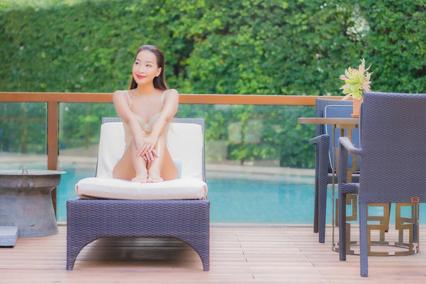 Retrato hermosa joven mujer asiática relajarse sonrisa alrededor de la piscina al aire libre en el complejo hotelero para vacaciones de viaje - Foto, imagen