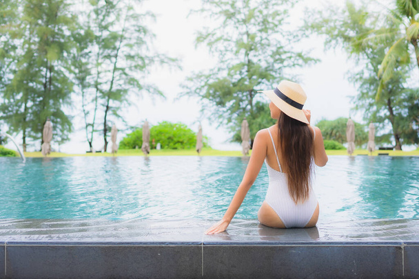 Retrato bonito jovem asiático mulher relaxar sorriso lazer ao redor piscina ao ar livre no hotel resort quase mar praia - Foto, Imagem