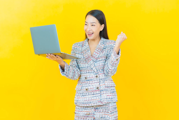 Portrait beautiful young asian woman smile with computer laptop on isolated background - 写真・画像