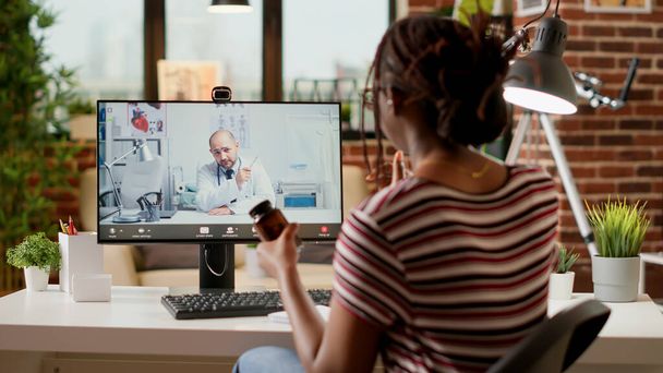 African american woman meeting with medic on videocall, attending telemedicine videoconference with webcam to discuss about healthcare and treatment. Online telehealth conference. - Foto, Imagen