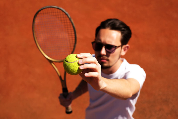 férfi teniszező játszik a pályán tartja a labdát, hogy szolgálja - Fotó, kép