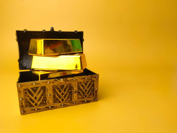 A treasure box with gold bar on a yellow background - Zdjęcie, obraz