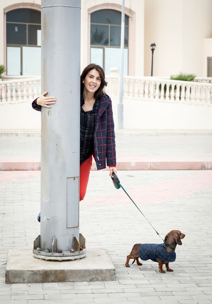 Women walking around town with dachshund dog - Фото, зображення