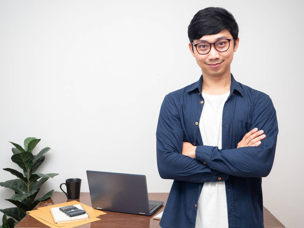 Θετικά γυαλιά επιχειρηματία χαμόγελο σταθεί σταυρό χέρια αυτοπεποίθηση στο χώρο εργασίας τραπέζι - Φωτογραφία, εικόνα