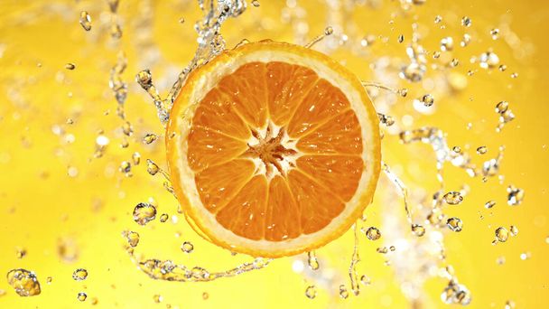 Slice of orange with water splashes on colored background. Isolated studio shot, fresh fruit background. - Fotoğraf, Görsel