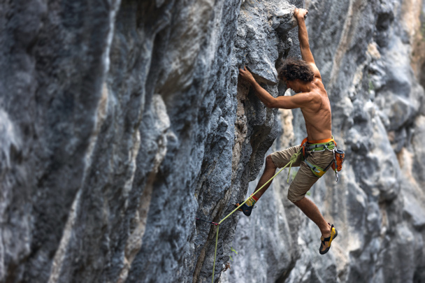 escalador de rocha sobe a rocha. um homem forte supera uma rota difícil. relaxamento e liberdade na natureza. - Foto, Imagem
