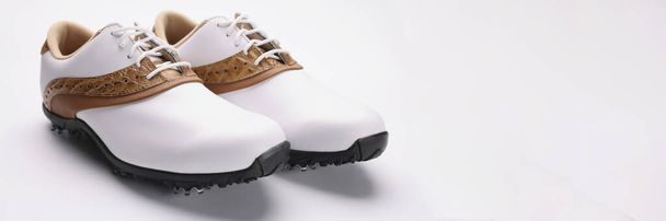Primer plano de un par de elegantes zapatos de moda con un diseño único, el cuero blanco se combina con oro, cosas de metal en la suela. Calzado, moda, concepto de diseño - Foto, imagen