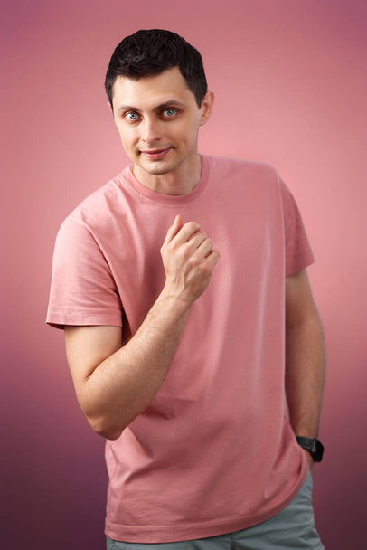 handsome man in t-shirt looking at the camera on pink background - Foto, Imagen