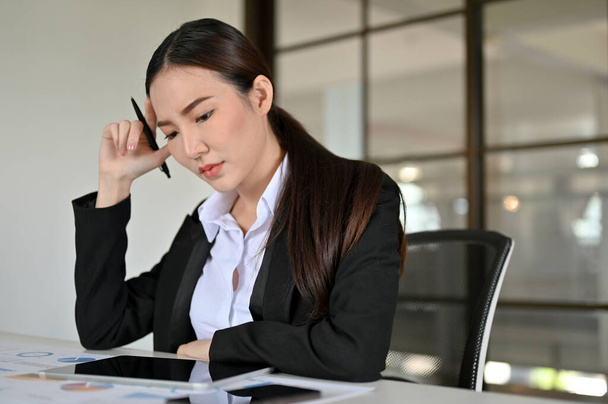 Professionelle junge asiatische Geschäftsfrau oder Kauffrau konzentriert an ihrer Aufgabe im Büro arbeiten.  - Foto, Bild