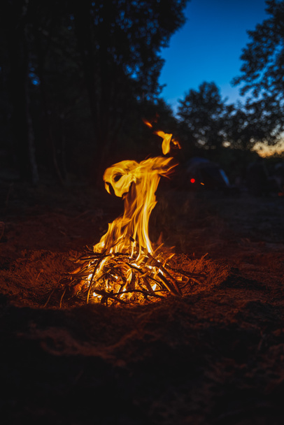 Oheň ve večerním táboře. Přežití a dobrodružství ve venkovské oblasti. Malý táborák v létě - Fotografie, Obrázek