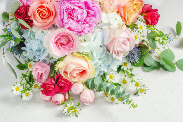 Hromada květin na bílém mramorovém stole, pestrobarevné slavnostní a svatební kytice - Fotografie, Obrázek